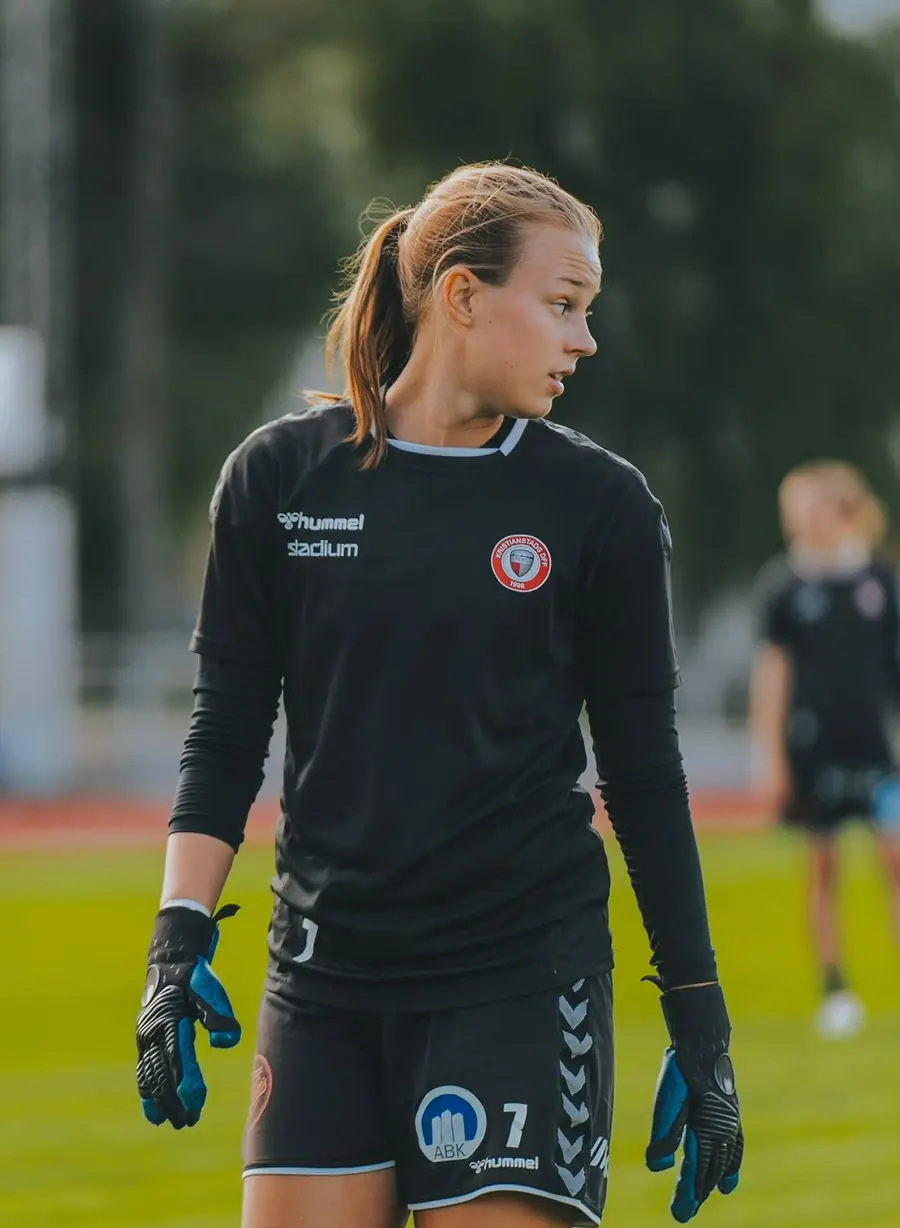 Jeune gardienne debout dans sa surface, regard porté vers le jeu