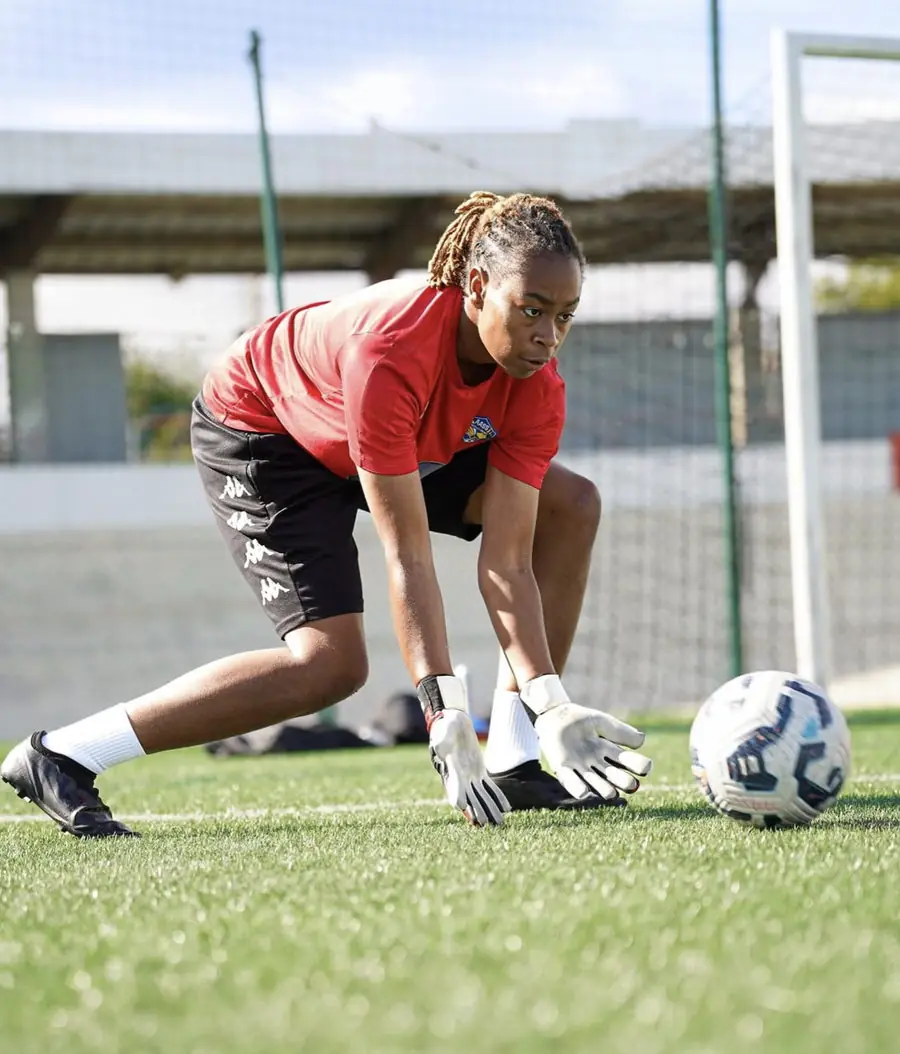 Gardienne en appui bas, mains au sol, prête à cueillir le ballon